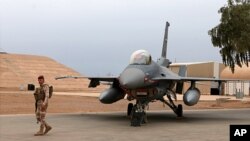 FILE - An Iraqi soldier stand guard near a U.S.-made Iraqi Air Force F-16 fighter jet, at Balad Air Base, north of Baghdad, Iraq, Feb. 13, 2018. 