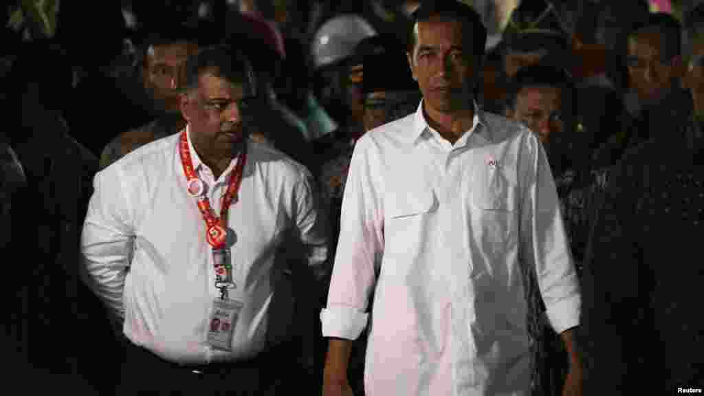 Le président Joko Widodo de l&#39;Indonésie, à droite, marche à côté de Tony Fernandes, PDG d&#39;AirAsie après une rencontre avec les membres de la famille des passagers à bord AirAsie vol QZ8501 à l&#39;aéroport international de Juand, Surabaya, 30 décembre 2014.