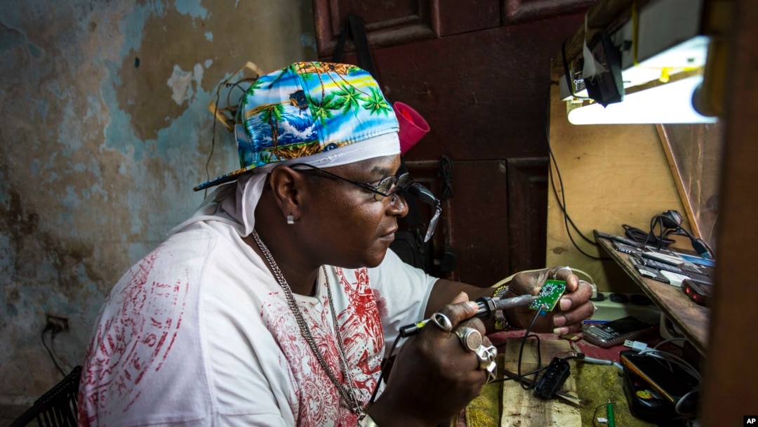 Teknisi perhiasan dan elektronik Gabriel La O memperbaiki sebuah ponsel di dalam toko pemerintah yang ia sewa di Havana, Kuba (24/5). (AP/Desmond Boylan)