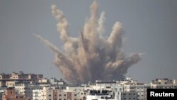 Humo y arena se elevan luego de un ataque israelí en Gaza.