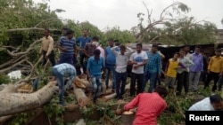 Warga setempat memindahkan kayu-kayu pohon yang tumbang dari jalan pasca angin kencang dan badai debu melanda kawasan Alwar, negara bagian Rajasthan, India, 3 Mei 2018. 