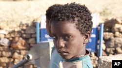 A girl holding sugarcane at a well in Endaselassie. Ethiopia. (Photo: Water.org)