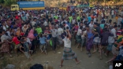 A Rohingya Muslim, who crossed over from Myanmar into Bangladesh, beats other refugees as a fight broke out during a distribution of aid near Balukhali refugee camp, Bangladesh, Sept. 25, 2017.