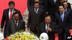 Laos President Bounnhang Vorachith, foreground right, walks together with Cambodian Defense Minister Tea Banh, foreground left, during a ceremony to pay respects at the Monument Independence in Phnom Penh, Cambodia, Wednesday, Feb. 22, 2017. (AP Photo/Heng Sinith)