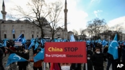 A protester from the Uyghur community living in Turkey holds an anti-China placard during a protest against the visit of China's Foreign Minister Wang Yi to Turkey, in Istanbul, March 25, 2021. 