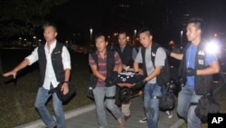 Ken Tsang, center, a member of a local pro-democracy political party, is carried by plainclothes police officers after a clash between protesters and police in an occupied area near the government headquarters in Hong Kong, Oct. 15, 2014.