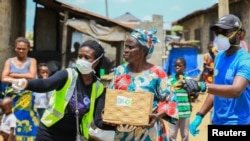 Volunteers gesture as they direct an elderly woman at an ongoing distribution of food parcels, during a lockdown by the authories in efforts to slow the spread of the coronavirus disease (COVID-19), in Lagos, April 9, 2020.