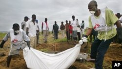 Des employés de MSF enterrant des morts à Monrovia, au Libéria (AP)