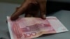 Un empleado de una casa de cambio muestra un billete de 100 yuanes chinos en La Paz, Bolivia, el 26 de julio de 2023.