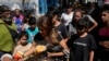 ARCHIVO: Personas reciben comidas calientes gratuitas en un comedor comunitario dirigido por el Movimiento de Trabajadores Excluidos (MTE) en Buenos Aires, Argentina, el viernes 8 de marzo de 2024.