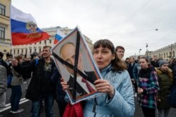 FILE - Opposition activists participate in a rally against Russian President Vladimir Putin, in Saint Petersburg, Russia, May 5, 2018.