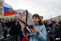 FILE - Opposition activists participate in a rally against Russian President Vladimir Putin, in Saint Petersburg, Russia, May 5, 2018.