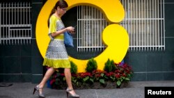 Una empleada de Globovisión camina frente a al edificio principal de la televisora, censurada por el gobierno por octava vez en ocho años.