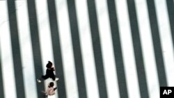 People wearing protective masks to help curb the spread of the coronavirus run along a pedestrian crossing in Tokyo. The Japanese capital confirmed more than 340 new coronavirus cases on Thursday. 