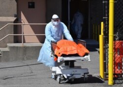 A medical staffer moves the body of a coronavirus victim from the Wyckoff Heights Medical Center to a refrigerated truck in Brooklyn, New York, April 2, 2020.