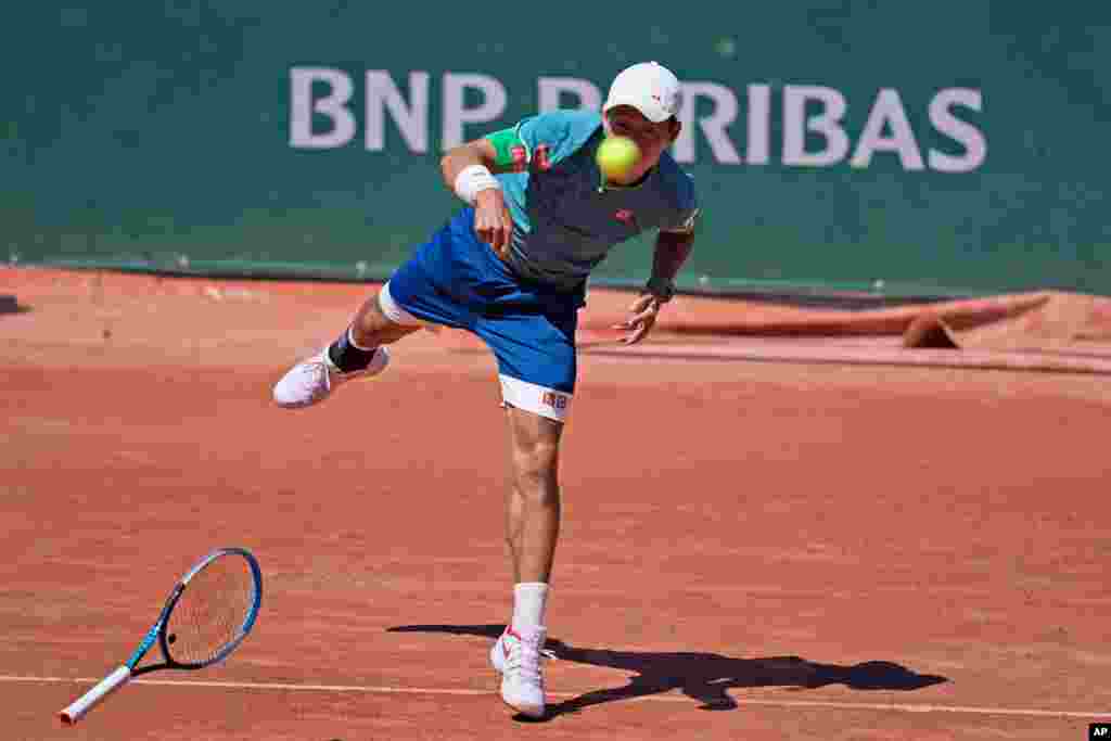 Japan&#39;s Kei Nishikori loses his racket as he serves the ball to Italy&#39;s Alessandro Giannessi during their first round match of the French Open tennis tournament at the Roland Garros stadium in Paris.