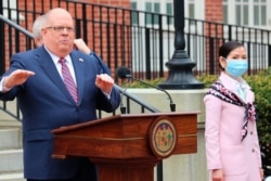 Maryland Gov. Larry Hogan speaks at a news conference in Annapolis, Md., with his wife, Yumi Hogan, April 20, 2020. He announced that Maryland received supplies from a South Korean company to boost the state's ability to conduct tests for COVID-19.