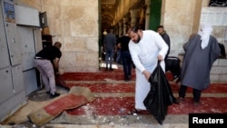 
فلسطینی شہری اسرائلی فوجیوں کے ساتھ جھڑپوں کے بعد مسجدِ قصیٰ کی صفائی کر رہے ہیں، 15 اپریل، 2022 