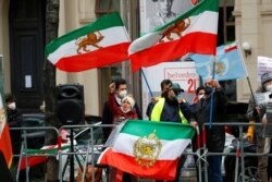 FILE - An Iranian opposition group protests outside a hotel, where a meeting of the JCPOA Joint Commission is held, in Vienna, Austria, April 15, 2021.
