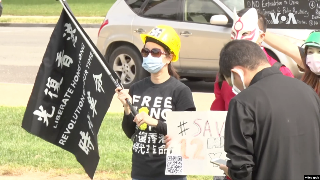 在美國首都華盛頓參加反對中共全球抗議日活動的港人拿著“光復香港 時代革命”的旗。