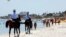 FILE - Mounted police officers patrol on the beach of Sousse, Tunisia, June 28, 2015. 