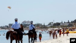 Des policiers patrouillent sur la plage de Sousse, Tunisie, le 28 juin 2015. 