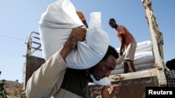 FILE: A man carries a sack of food aid from the WFP, at the Um Rakuba refugee camp in Sudan, December 3, 2020. 