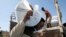 FILE: A man carries a sack of food aid from the WFP, at the Um Rakuba refugee camp in Sudan, December 3, 2020. 