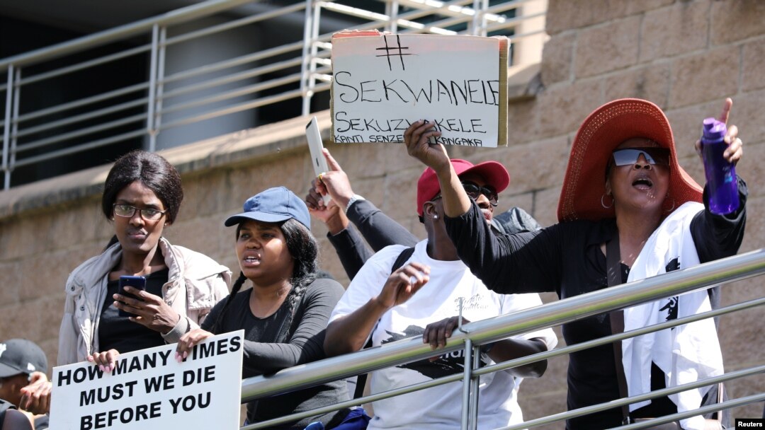 Mujeres sostienen pancartas mientras protestan contra la violencia de género, frente a la Bolsa de Valores de Johannesburgo en Sandton, Johannesburgo, Sudáfrica. [Foto de archivo]