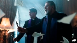 This image released by Sony Pictures shows Daniel Zovatto, left, and Russell Crowe in a scene from Screen Gems' "The Pope's Exorcist."