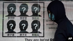 A university student puts up a poster to demand of releasing the 12 Hong Kong activists detained at sea by Chinese authorities. Sept. 29, 2020.