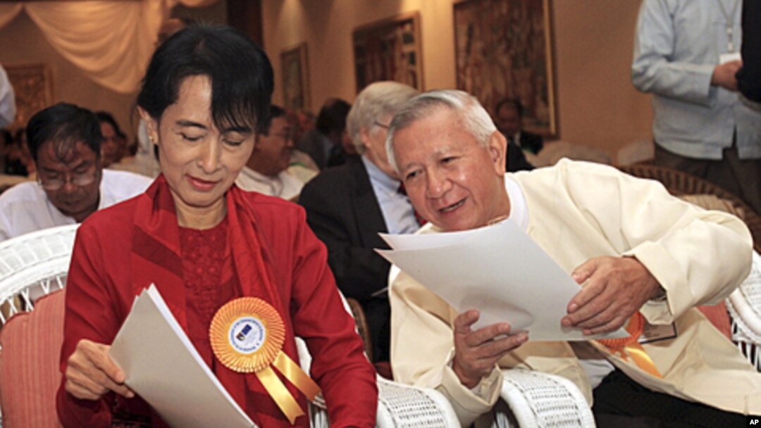 Burmese pro-democracy leader Aung San Suu Kyi and President's Economic Adviser U Myint read documents during a workshop on the development in Rangoon, November 7, 2011.