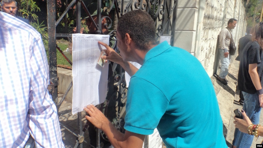 Un hombre revisa el número de su mesa electoral para ingresar a sufragar en Venezuela. [Foto: Alvaro Algarra, VOA].