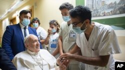 En esta imagen de archivo, el papa Francisco es recibido por el personal hospitalario a su entrada, en silla de ruedas, en el policlínico universitario Agostino Gemelli en Roma, el 11 de julio de 2021, antes de someterse a una operación intestinal. 