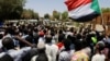 Sudanese demonstrators chant slogans in front of security forces during a protest in Khartoum, Sudan, Apr. 15, 2019. 