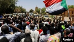 Sudanese demonstrators chant slogans in front of security forces during a protest in Khartoum, Sudan, Apr. 15, 2019. 