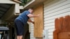 A man boards up the windows to his home in advance of Tropical Storm Helene, expected to make landfall as a hurricane, in Ochlockonee Bay, Florida, Sept. 25, 2024.