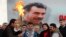 Selahattin Demirtas (front C), co-chairman of the pro-Kurdish Peace and Democracy Party (BDP), lights a traditional Newroz fire during a rally to celebrate the spring festival of Newroz - with a picture of imprisoned PKK leader Abdullah Ocalan seen in the