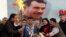 Selahattin Demirtas (front C), co-chairman of the pro-Kurdish Peace and Democracy Party (BDP), lights a traditional Newroz fire during a rally to celebrate the spring festival of Newroz - with a picture of imprisoned PKK leader Abdullah Ocalan seen in the