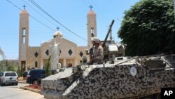 A Lebanese army soldier from the special forces unit stands on a APC during a patrol in front a church in Qaa, a predominantly Lebanese Christian village near the Syrian border were suicide bombers blow themselves among civilians on Monday, eastern Lebano