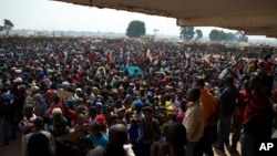 People wait to receive food and supplies from an aid distribution point set up inside a makeshift camp at Mpoko Airport in Bangui, Jan. 7, 2014.