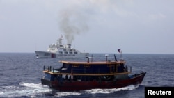 资料图片：2023年10月4日，一艘菲律宾补给船驶近一艘中国海警船，当时菲律宾补给船在为驻扎在南海一艘搁浅军舰上的菲律宾部队执行补给任务。（路透社）