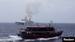 Sebuah kapal pasokan Filipina berlayar di dekat kapal Penjaga Pantai China di Laut China Selatan, 4 Oktober 2023. (Foto: REUTERS/Adrian Portuga)