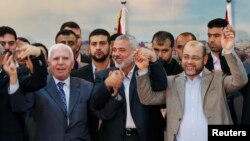 Pemimpin Fatah Azzam Al-Ahmed (kiri), pemimpin Hamas Ismail Haniyeh (tengah) dan Moussa Abu Marzouq bergandeng tangan saat rekonsiliasi di Gaza bulan April lalu (foto: dok).