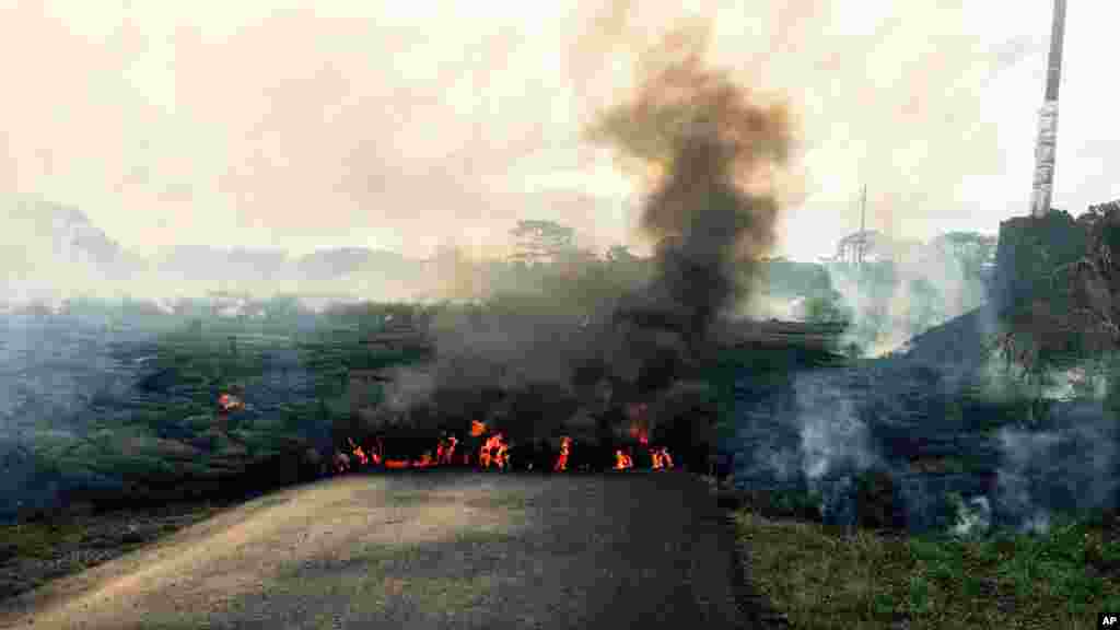 In this photo from the U.S. Geological Survey, the lava flow from Kilauea Volcano that began June 27 is seen as it crosses Apaa Street near the town of Pahoa, on the Big Island of Hawaii, Oct. 24, 2014. 