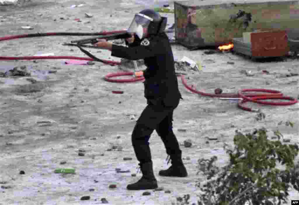 An Egyptian riot policeman fires at protesters in Suez, Egypt Thursday, Jan. 27, 2011. Egyptian activists protested for a third day as social networking sites called for a mass rally in the capital Cairo after Friday prayers, keeping up the momentum of th