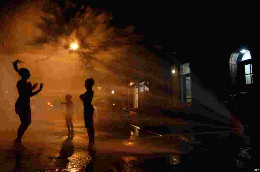 July 20: Vanity Mendez, 11, left, Isaiah Rivera, 6, center, and Jonathan Medina, 11, cool off at a fire hydrant in the East Village of Manhattan. A heatwave that has enveloped much of the central part of the country and temperatures are expected to top 