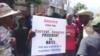 Protesters in Port-au-Prince, Haiti hold a poster demanding the US stop propping up the country's president during a protest, Friday, Oct. 4, 2019. (Photo: Matiado Vilme / VOA Creole) 