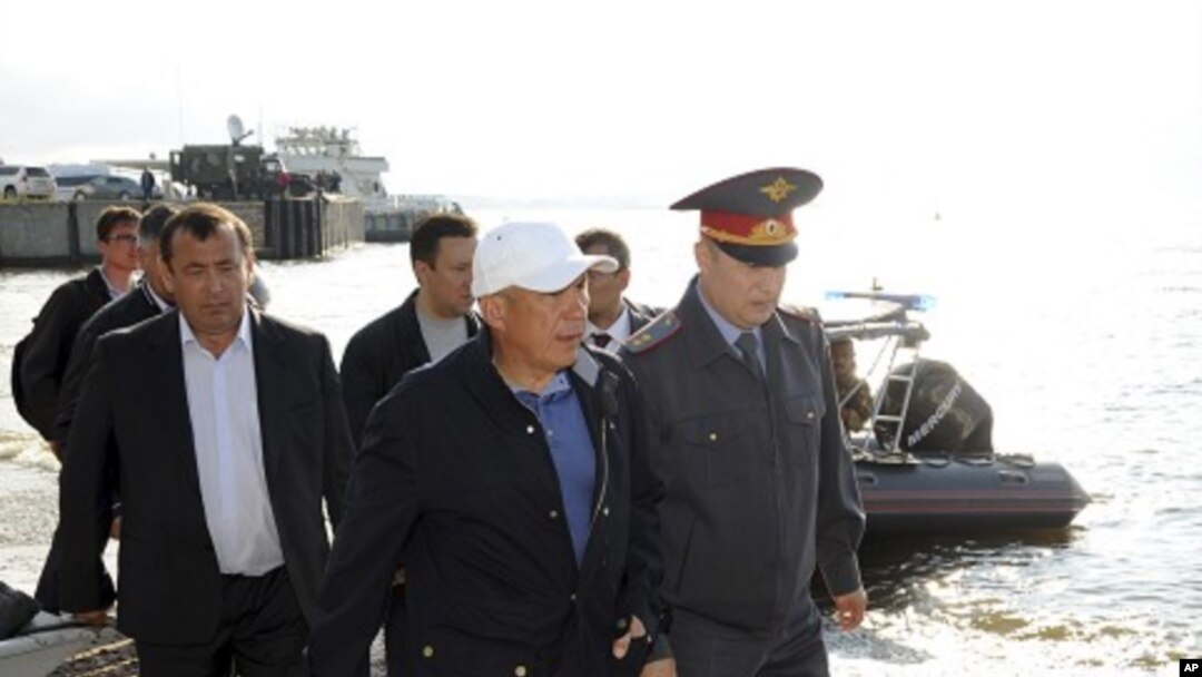 Tatarstan President Rustam Minnikhanov (2nd R front) walks along the bank of the Volga river during the operation to search for the missing people from the tourist boat "Bulgaria" in Russia's Tatarstan region July 11, 2011.
