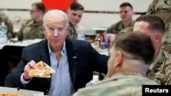 Presiden AS Joe Biden makan pizza bersama anggota pasukan AS di Rzeszów, Polandia hari Jumat (25/3). 